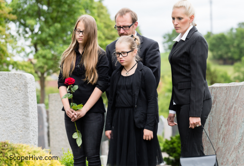 A group of people dressed in smart casual attire, some wearing dark colors, others in brighter tones, gathered in a tastefully decorated venue with flowers and candles